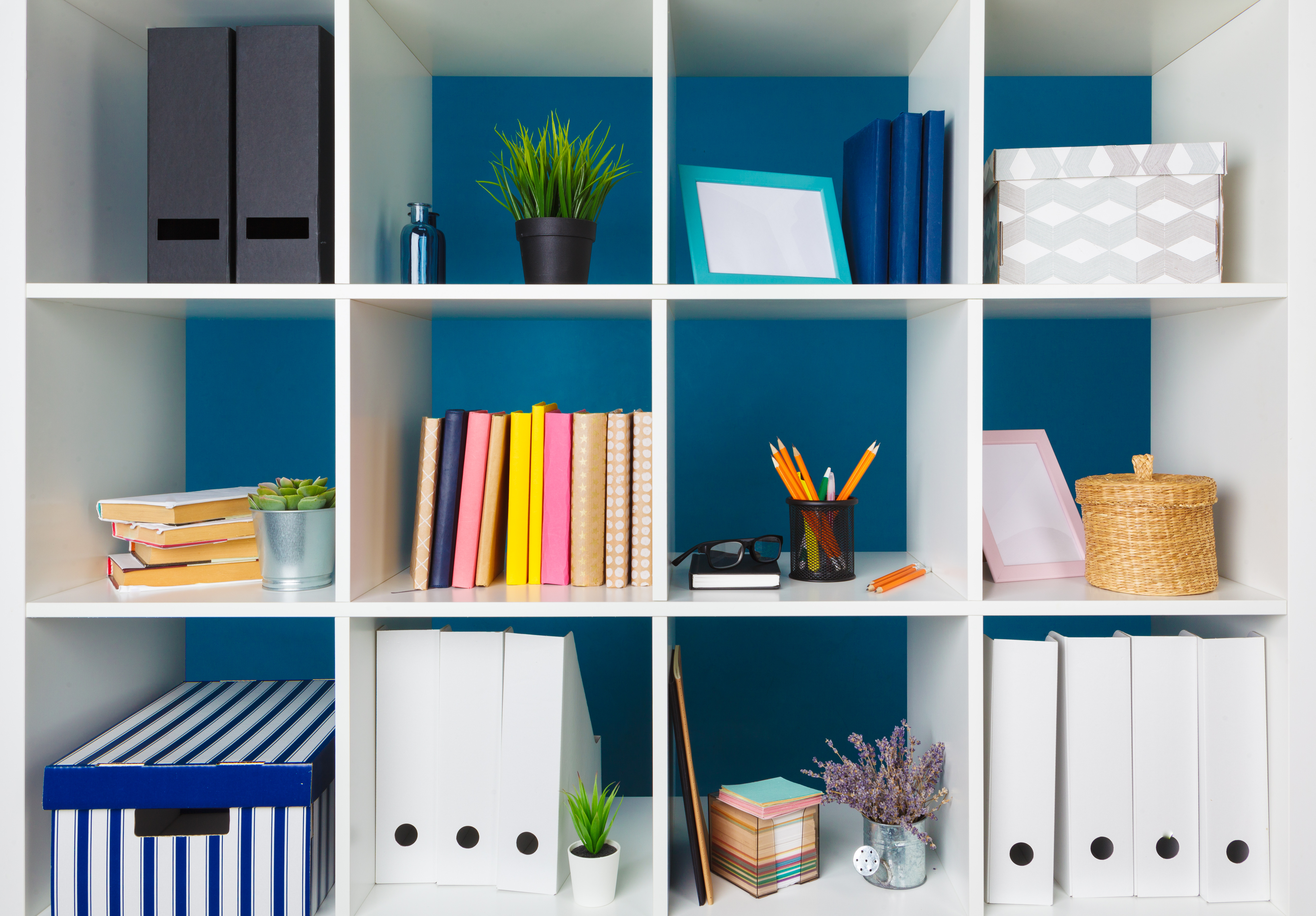 White office shelves with different stationery, close up